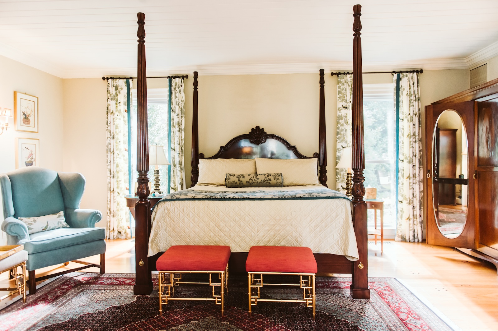 A guest room with a queen bed, sitting area, and bright windows at a bed and breakfast north carolina.