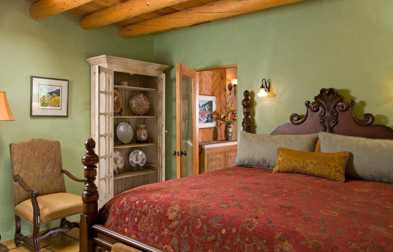 A bed and sitting area in a green room with a wooden ceiling at the best bed and breakfast Santa Fe.