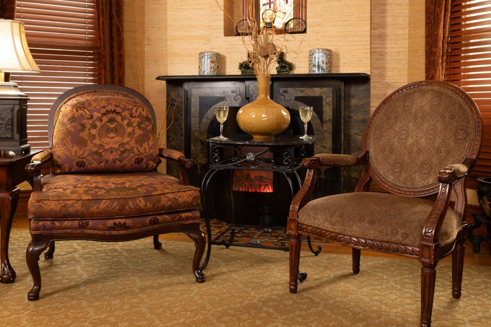 The sitting area in the Miss Yunji Room is a perfect place to relax after exploring our area. Two chairs in front of fireplace, glasses of wine sit on table