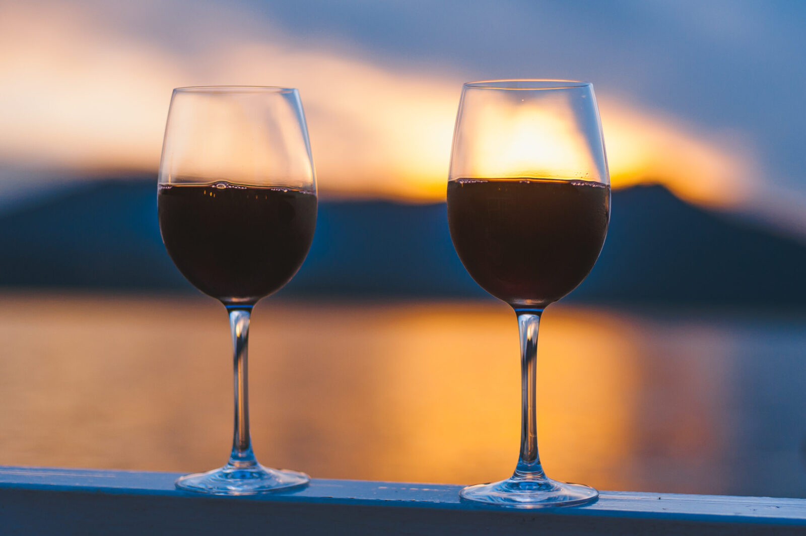 wine glasses with red wine, view of river at sunset, Domaine Pouillon Winery