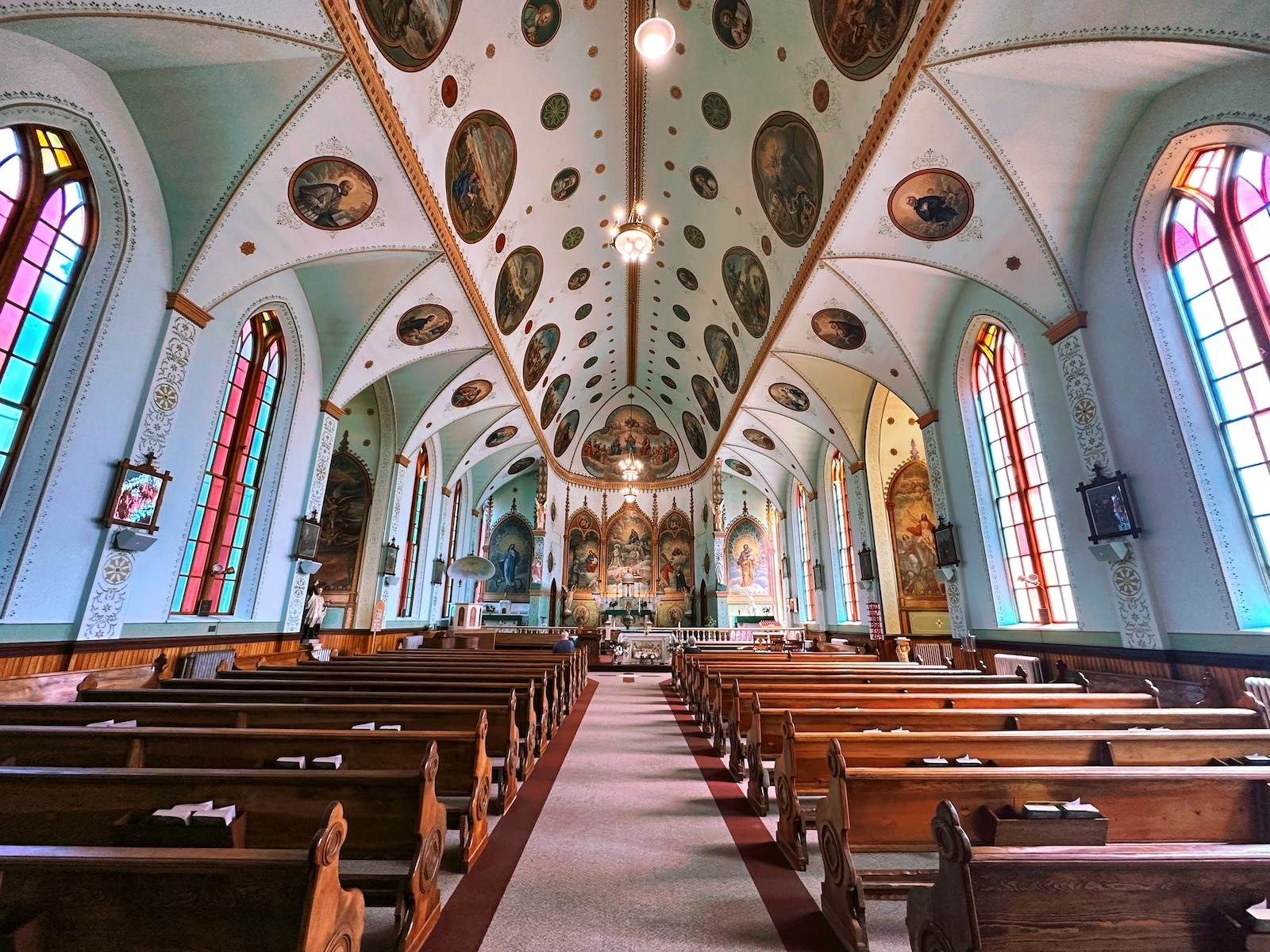 The St. Ignatius Montana, a chapel with pews, an ornate ceiling, and colorful windows, one of the unique things to do in Montana.