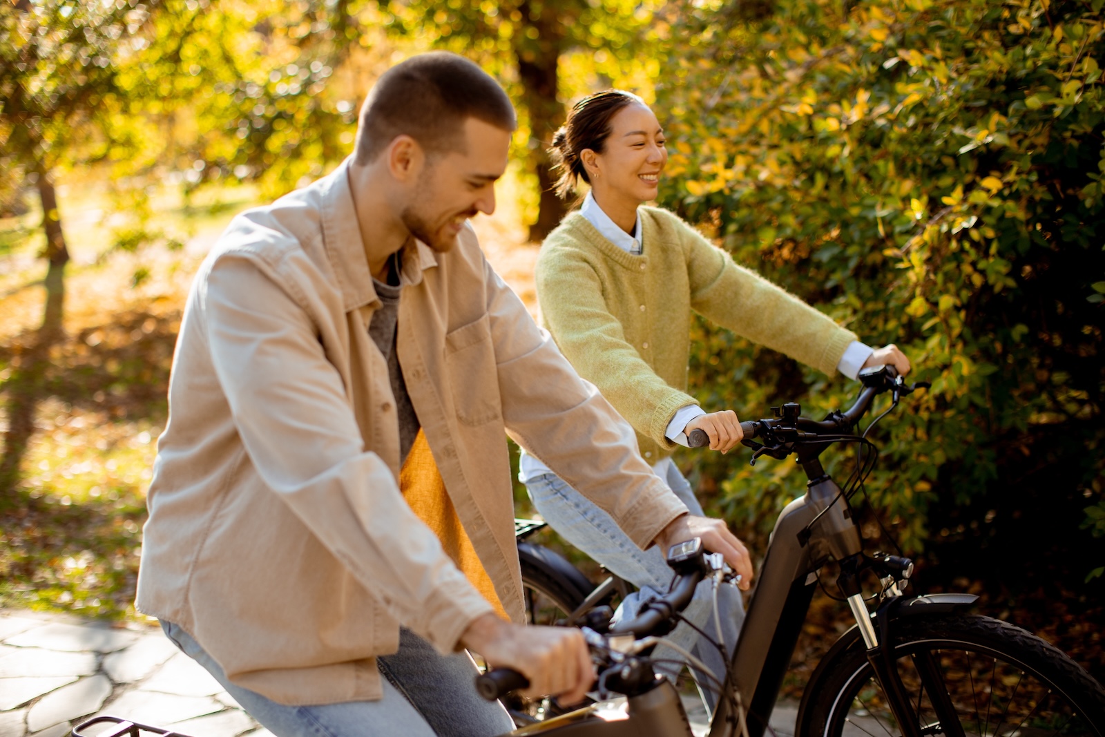 A man and woman riding bikes with fall colors surrounding them during one of the best fall getaways in Wisconsin.