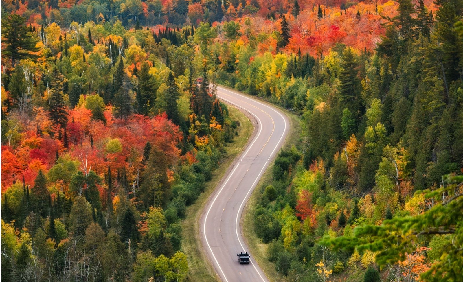 Scenic Minnesota highway leading toward small town weekend getaway destinations near Minneapolis.