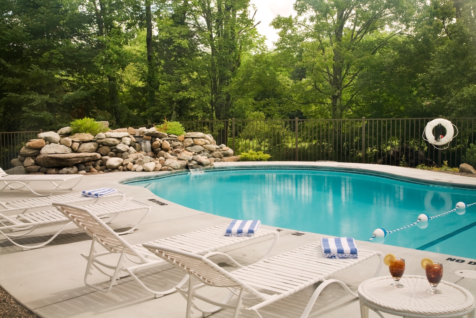 A pool with seating at a Bed and Breakfast in New Hampshire.