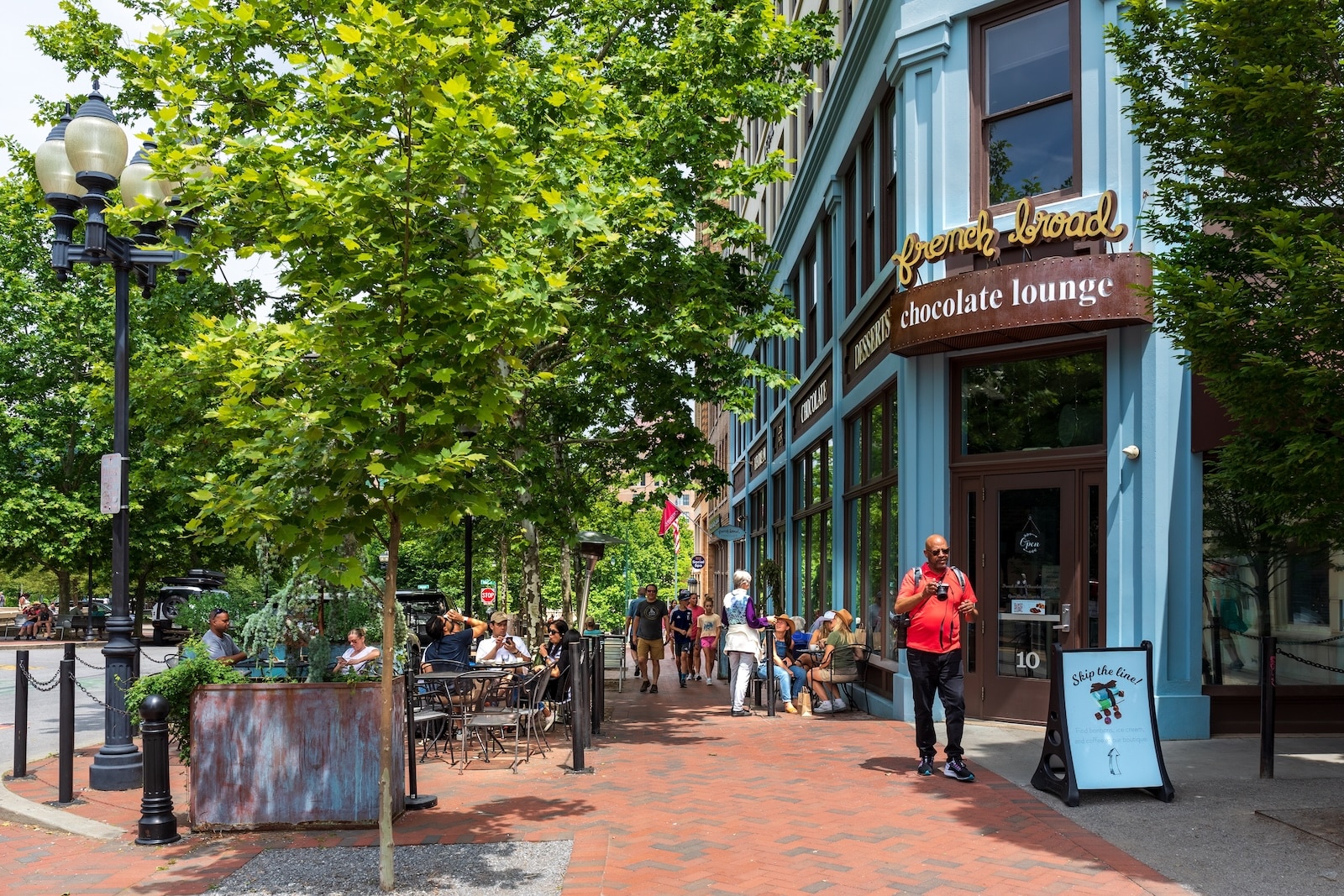 Sidewalk diners outside the French Broad Chocolate Lounge near Pack Square in Asheville, NC, one of the best North Carolina mountain towns.
