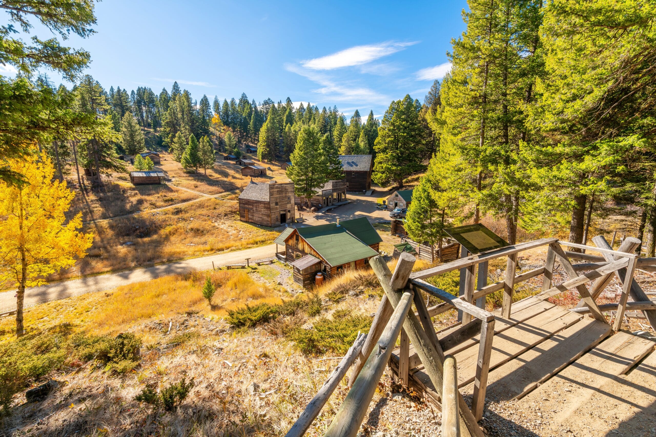 View of the Garnet Ghost Town in Montana with old buildings surrounded by evergreen trees.