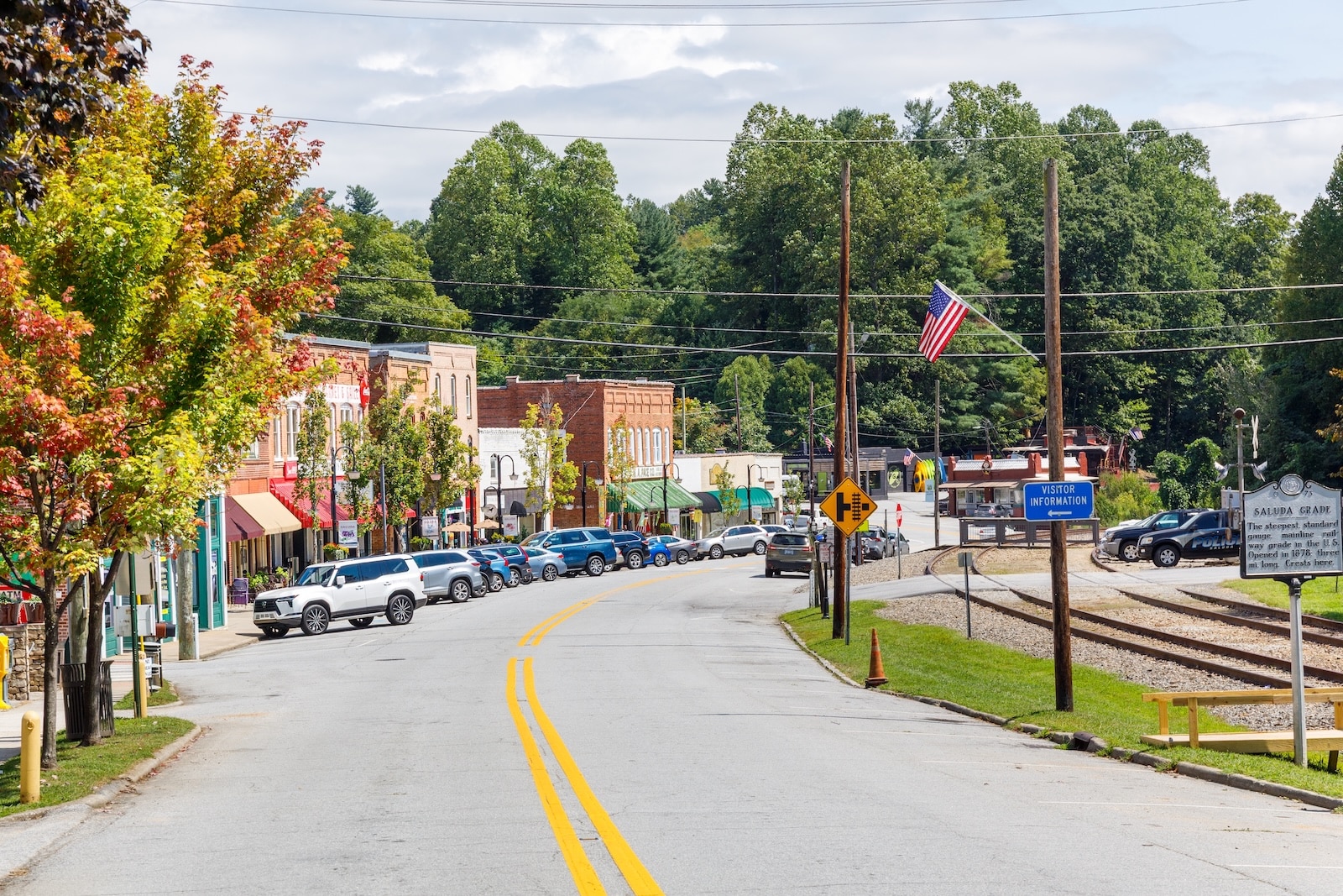 Downtown Saluda, North Carolina, one of the best small towns in North Carolina with buildings lining a road by a railroad track.