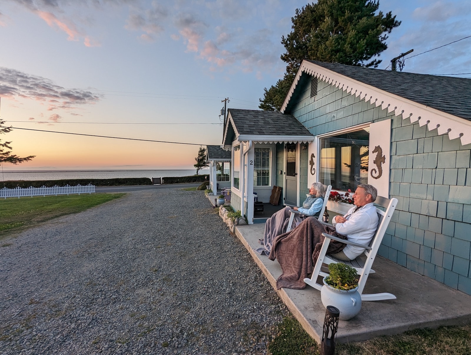 A couple enjoying a sunset over the Dungeness Bay at Sequim Cottages, one of the best anniversary getaway ideas.