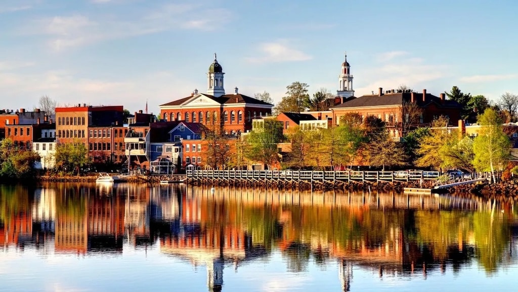 Enjoy this view of the town from across the river while on a walking tour of historic downtown Exeter NH. Tree lined walkway along the town across the river.